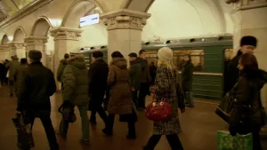 Foto van een druk metrostation in Moskou, er staat ook een metrotrein.