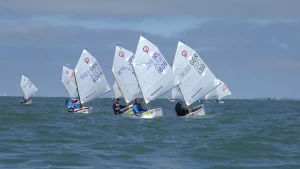 Foto van aantal kleine zeilboten, optimisten, die varen op de volle zee.
