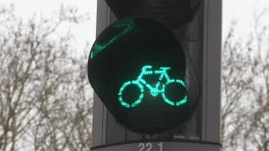 Foto, close-up, van een fietserstoplicht waarbij je het groene licht ziet, dus een groen lichtgevend fietsje.