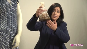 Foto van een vrouw die een soort glazen fles, een erlenmeyer, vasthoudt met mest erin.