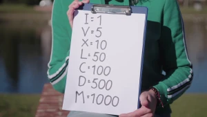 Foto van iemand die vel met alle soorten Romeinse cijfers vasthoudt met de waarden erbij van de normale cijfers.