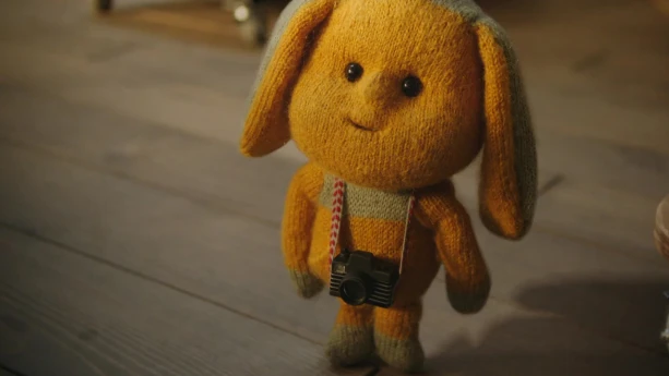 Foto van dierachtige stoffen pop, Dropje, die op de grond staat.