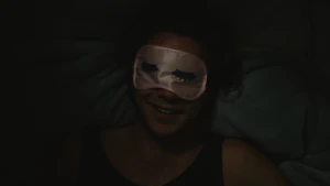 Foto, heel donker, van een portret van iemand die een ogenmaskertje op heeft.