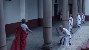 Foto van Julius Caesar en zijn tegenstanders die hem komen vermoorden in zuilengalerij gebouw, voorste tegenstander houdt mes/dolk vast..