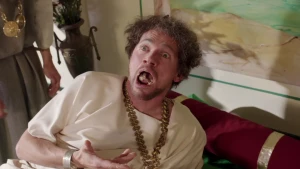 Foto van acteur in Romeins gewaad, die verschrikt opkijkt met eten in zijn mond.