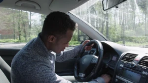 Een foto van presentator Habtamu die in een auto zit en de sleutel omdraait zodat de motor van de auto aan gaat.