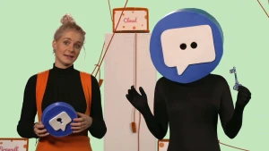 Een foto van Janouk die een rond blauw ding vastheeft, met daarop een sleutelgat in een witte teksballon. Rechts staat iemand met een sleutel in één hand en een groot, rond blauw ding op zijn of haar hoofd met in het midden puntjes in een tekstballon.