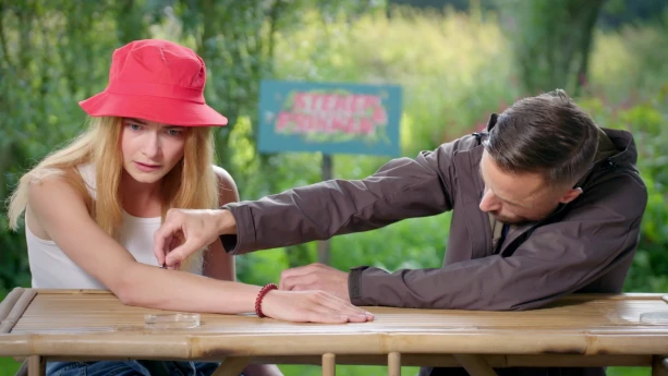 Een foto van een man die een waterschorpioen op een arm houdt van presentator Emma.