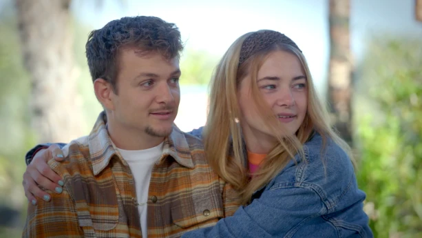 Een foto van Jurre en Emma die naar iets kijken wat buiten beeld is. Emma omhelst Jurre terwijl ze ernaar kijken.