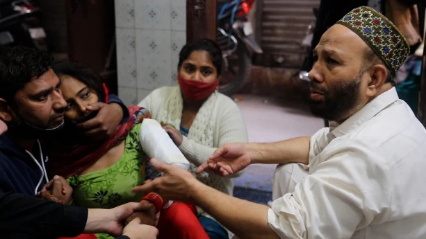 Een foto van twee mannen en twee vrouwen. Ze zitten binnen. Een man lijkt de arts te zijn, en een van de vrouwen is de patiënt. 