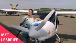 Een foto van Nizar in zomerse kleding die leunt tegen de zijkant van een wit elektrisch vliegtuig waar twee mensen inpassen. Het heeft een propeller met drie wieken en twee brede vleugels. Linksonder staat in een rode driehoek "Met Lesbrief".