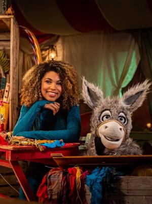 Ezel Chiel en de presentatrice Anne zitten naast elkaar in een ruimte. 