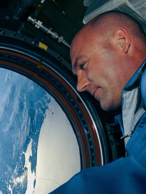 André Kuipers kijkt uit op blauwe aarde via raampje