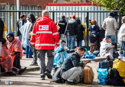 Hulpverlener van Rode Kruis tussen vluchtelingen