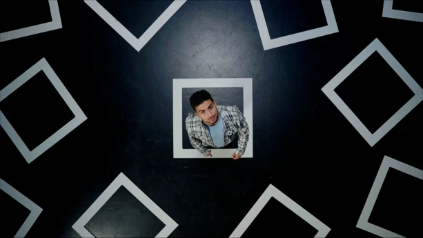 Een foto van presentator Nizar die in een vierkant op de grond staat wat een hokje moet voorstellen. In de foto zijn meerdere hokjes te zien.