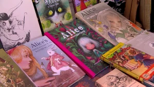 Een foto waarop verschillende uitgaven van het boek Alice in Wonderland van schrijver Lewis Carroll te zien zijn die uitgestald liggen op een marktkraam.