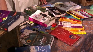 Een foto van een marktkraam vol met op papier gedrukte boeken die allemaal ook als audioboek uitgegeven zijn.