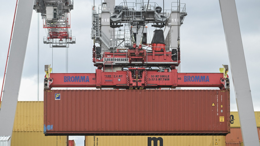 Rode container in de lucht vervoerd door grote grijparm