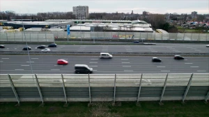 Een foto van een snelweg van de zijkant genomen. Er rijden verschillende auto's op aan beide kanten.