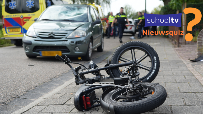 Een op de grond gevallen fatbike met een auto, politie en ambulance erbij. Er is duidelijk sprake van een ongeluk, maar je ziet geen gewonden.