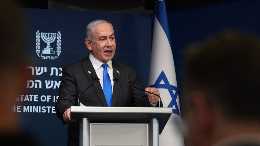 Premier Netanyahu achter spreekgestoelte met Israelische vlag achter hem.