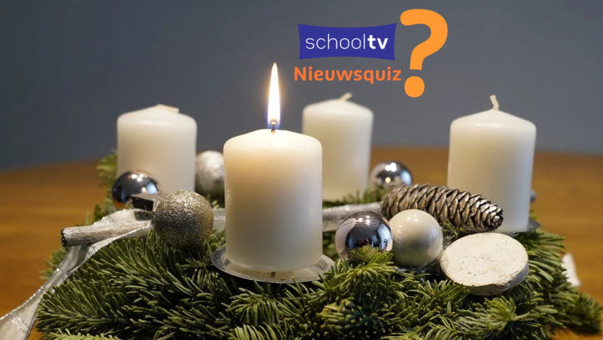 Op deze foto zie je een brandende witte kaars op een adventskrans. Ook het Schooltv Nieuwsquiz logo is te zien in het blauw en oranje.