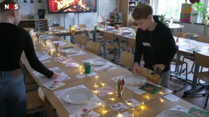 Een foto van twee kinderen, zij dekken lange tafel