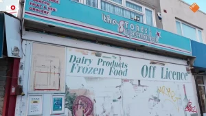 Foto van een gesloten en vervallen Britse supermarkt met reclameteksten.