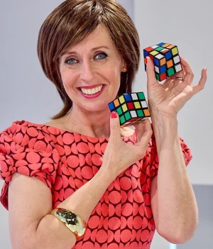 Foto van presentatrice Dorine Goudsmit met twee rubiks kubussen in het decor van Welkom in de geschiedenis