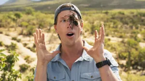 Foto van Freek Vonk die met verbazing kijkt naar een gigantische spin die over zijn hoofd kruipt.