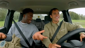 Een foto van zanger Claude en presentator Floris in een auto, Floris rijdt, Claude zit er naast.