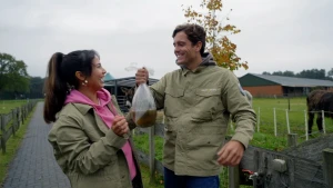 Een foto van twee mensen die een zak vasthebben met iets van water erin.