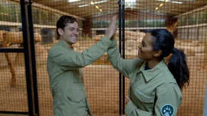 Een foto van Floris en Sosha die voor een hok staan en elkaar een high five geven.