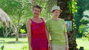 Een foto van beide presentatoren, Jurre heeft een rode jurk aan, Emma een groen shirt met beige broek en hoed.