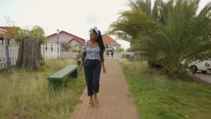 Een foto van een vrouw, ze loopt door een straat op St Eustatius. 