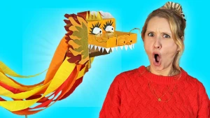 Foto van presentatrice Rosalie die geschrokken in de camera kijkt met een geknutselde draak naast zich met scherpe tanden.