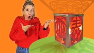 Foto van presentatrice Rosalie bij een geknutselde vierkante lamp met rode Chinese tekens.