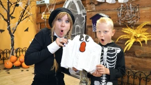 Foto van presentatrice Rosalie met zelfgeknutseld spookje en jongen in skeletpak.