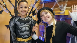 Foto van presentatrice Rosalie met jongen in batmanpak en zelfgeknutselde vleermuis.