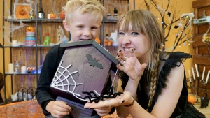 Foto van presentatrice Rosalie met kind en zelfknutseld vleermuizenspookhuis.