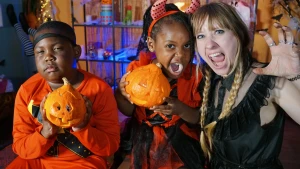 Foto van presentatrice rosalie met twee kinderen die zelf een pompoen hebben geknutseld voor halloween.