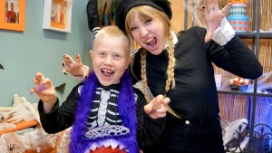 Foto van presentatrice Rosalie met kind en zelfgeknutselde tas in de vorm van een paars monster.