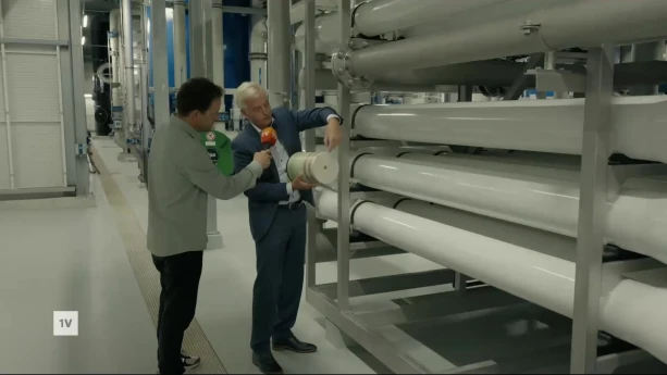 Een foto van een man die een filter laat zien aan de verslaggever, daarmee kun je PFAS uit drinkwater filteren.