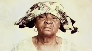 Surinaamse vrouw met traditionele doek op haar hoofd en ringen in haar oren