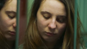 Meisje kijkt somber in de spiegel. Ze kijkt naar beneden.