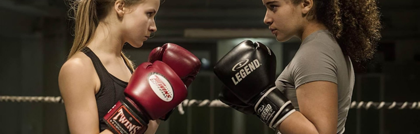 Twee meisjes met bokshandschoenen staan tegenover elkaar in de boksring.