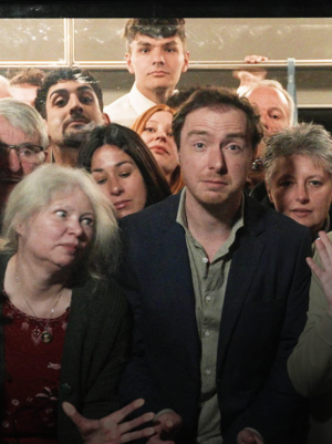 Foto van een groep mensen in een metro die naar buiten kijken.