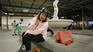 Een foto van presentator Pascal in een skatepark, hij heeft een helm op en skates aan.