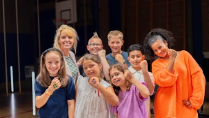 Stephanie van Eer en Darren staan met kinderen en Anne-Mar. Ze hebben een gebalde vuist met stippen erop.