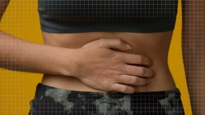 Een foto van een persoon van borst tot heupen, ze houdt haar hand op haar blote buik gedrukt. 